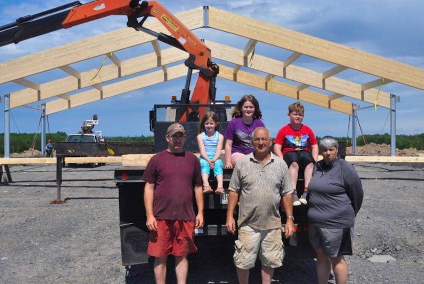 The Fergusons and their ancestors have been farming in Pictou since the 1800s. Pictured in back are the sixth generation of Fergusons: Ella, Payton and James. In front are Blake, William and Terri Ferguson. Behind them is the beginning of a new barn being built on the property.