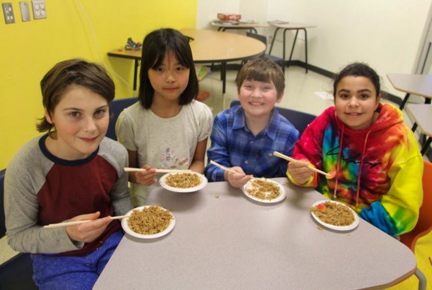 from the left: Caden Campbell, Lucy Li, Tristan Grant and Rebecca Paris enjoy their lunch of rice and candy.