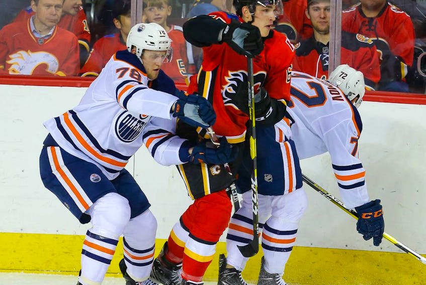 The Calgary Flames’ Adam Ruzicka battles Dmitri Samorukov and Kirill Maksimov of the Edmonton Oilers during a prospects game at Scotiabank Saddledome in Calgary on Sept. 10, 2019. Al Charest/Postmedia