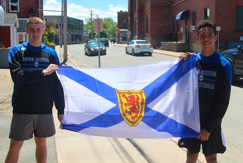 Nicholas Dayman (left) and Anthony Sears will show their basketball skills on a national stage later this summer, as Team Nova Scotia U15 members. They will be taking this Nova Scotia flag with them to Kamloops, B.C., in August, one that will be emblazoned with signatures from supporters. Corey LeBlanc