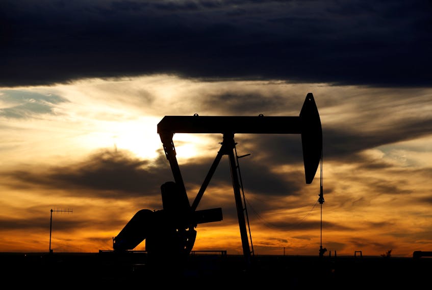 The sun sets behind a crude oil pump jack on a drill pad in Loving County, Texas. Refineries around the world are trimming production as demand slumps due to the coronavirus. REUTERS/Angus Mordant/File Photo
