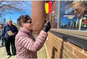 Rita Doucette smiles at Alcide LeBlanc while waving a Belgium flag. A few legion members and others gathered outside Veterans Place in Yarmouth for a few minutes on March 21 to sing Happy Birthday to LeBlanc, who was marking his 100th birthday. TINA COMEAU PHOTO