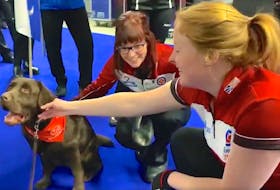 Newfoundland and Labrador skip and third Erin Porter (right) are introduced to a therapy dog before teams walked out for introductions prior to morning draw Monday at the 2020 Scotties Tournament of Hearts Canadian women’s curling championship in Moose Jaw, Sask. — Curling Canada/Twitter