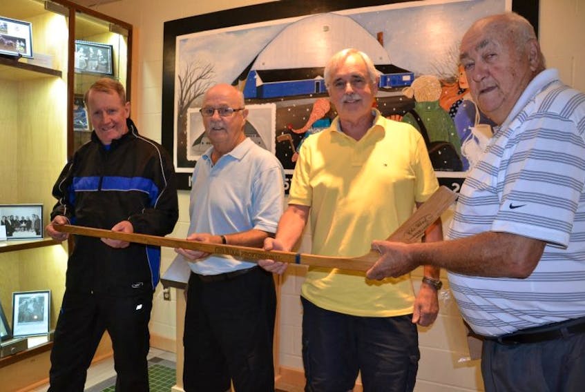 Northside Sports Hall of Fame committee members Matt Batherson, Bryan Cullen, Cyril Aker and Bob Gordon hold a stick the committee recently received. The stick was autographed by 1952-53 Northside Franklins team that upset Halifax St. Mary’s to win the Maritime Junior 'A' Hockey crown.