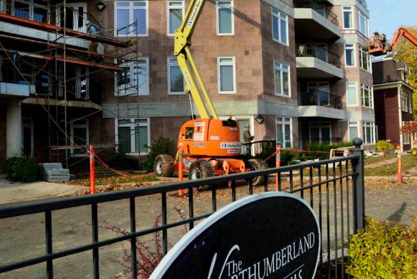 Crews fro William's Murphy and MacLeod work reparing the facade of the Northumberland Condominiums in Charlottetown.