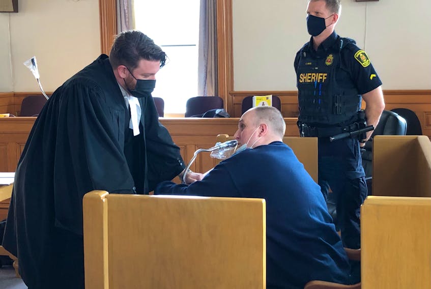 David Wayne Murray (seated) speaks to his lawyer, Tim O'Brien, after a sentencing hearing in Newfoundland and Labrador Supreme Court in St. John's Monday morning.