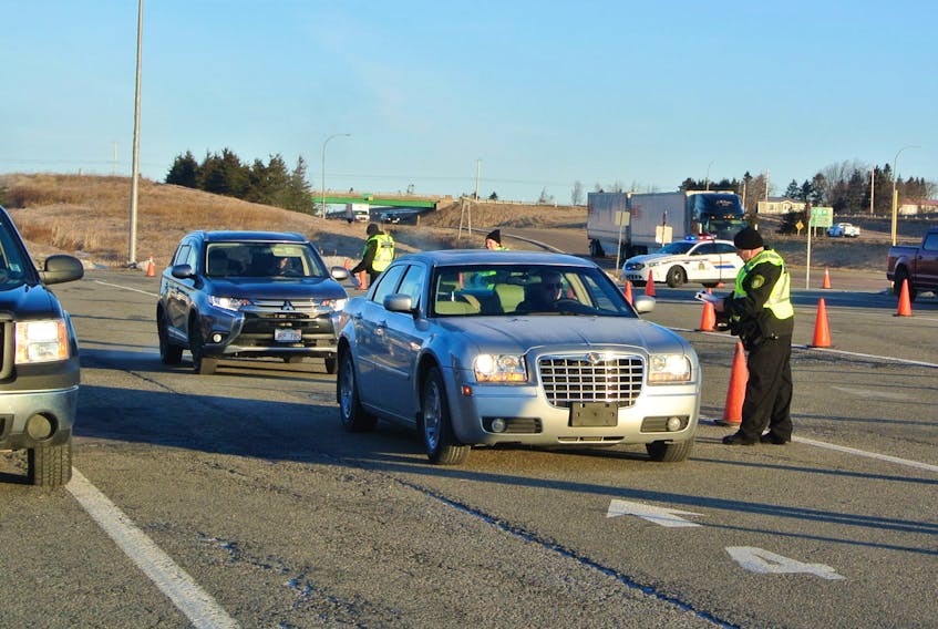 Provincial officials question motorists as they enter Nova Scotia at the inbound weigh scale in Fort Lawrence early Monday. RCMP were on hand to assist provincial officials as they tighten the border as a result of the province’s state of emergency declaration. DARRELL COLE/SALTWIRE NETWORK