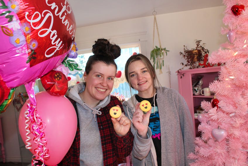 Aislinn MacIsaac, left, and Chelsea Parsons, front shop staff at Not Just Cakes Sweet Studio in Sydney River show off some emoji macarons that have been hot sellers at the dessert shop. Business has been good heading into Valentine’s Day. GREG MCNEIL/CAPE BRETON POST