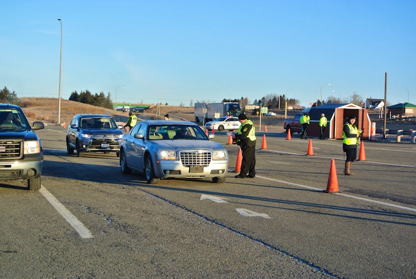 Provincial officials question motorists as they enter Nova Scotia at the inbound weigh scale in Fort Lawrence early Monday. RCMP were on hand to assist provincial officials as they tighten the border as a result of the province’s state of emergency declaration. Darrell Cole – Amherst News