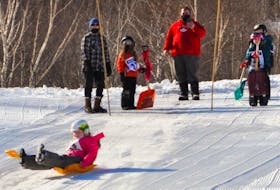 There’s more to Cape Smokey than just skiing and snowboarding as evidenced by a recent downhill shovel race. Above, a young participant slides down the hill on a bright, orange shovel. CONTRIBUTED