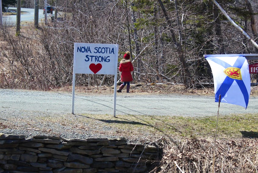 A Nova Scotia flag flies in the wind next to a hand-drawn sign of support for the victims of Canada's worst mass shooting April 18-19. Premier Stephen McNeil called on people across the province on Monday to display their Nova Scotia colours and tartans as a sign of solidarity and support for the victims, their families and their communities. NICOLE SULLIVAN/CAPE BRETON POST 