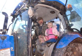Peter Greeno and his granddaughter Lexi Greeno do chores at NicNat Farm in Lorneville, Cumberland County. (AARON BESWICK PHOTO)