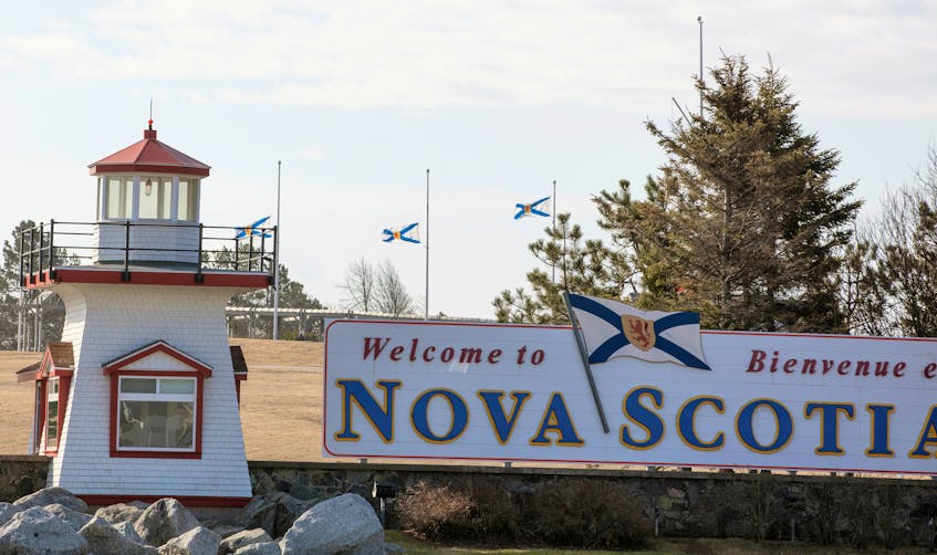 Nova Scotia flags are lowered on the New Brunswick/Nova Scotia border a day after a mass shooting by Gabriel Wortman, in Fort Lawrence.