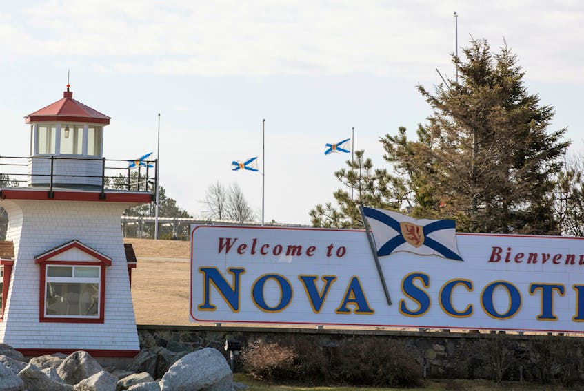 Nova Scotia flags are lowered on the New Brunswick/Nova Scotia border a day after a mass shooting by Gabriel Wortman, in Fort Lawrence.