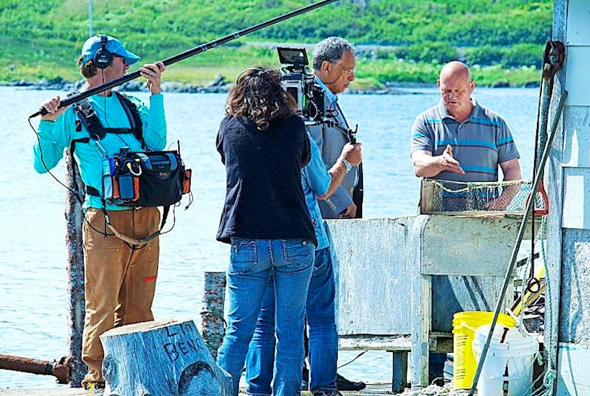 Noddy Bay fisherman Carl Hedderson, pictured, right, talks to professor Daniel Pauly, second from right, while being filmed for an international documentary about the contribution of small boat fishermen to the economy.