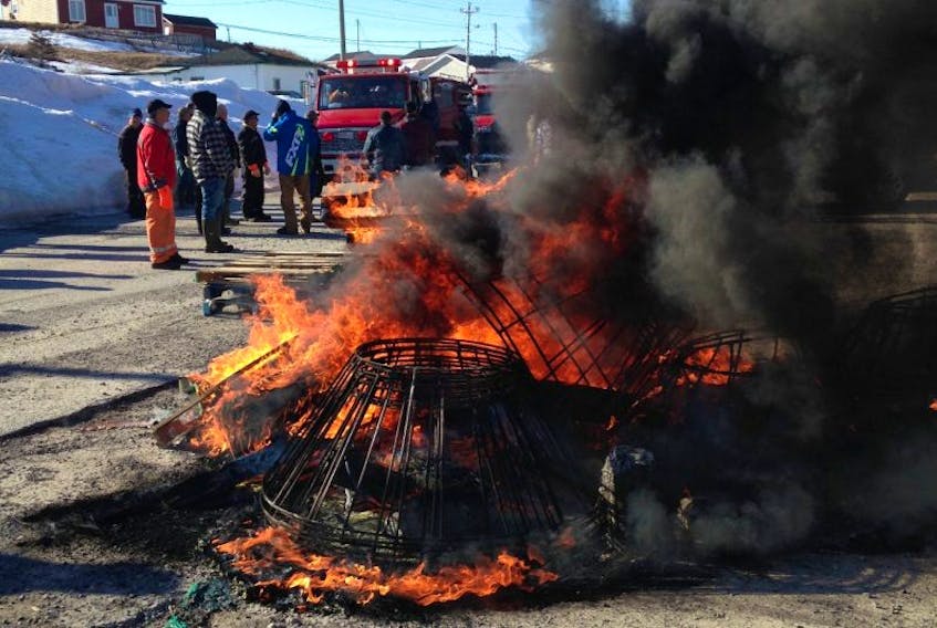 Harvesters set their fishing gear aflame in front of the DFO offices in Port au Choix Tuesday morning.