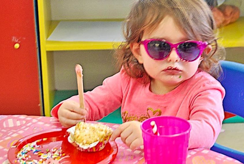 Two-year-old Jacquelyn Grimaldi looks cool as she eats her cupcake at the family resource centre, located at the College Building in Springdale. She was there with her mom Sue Holtby and her 10-month-old sister Juliana during the family’s visit back home from Toronto.