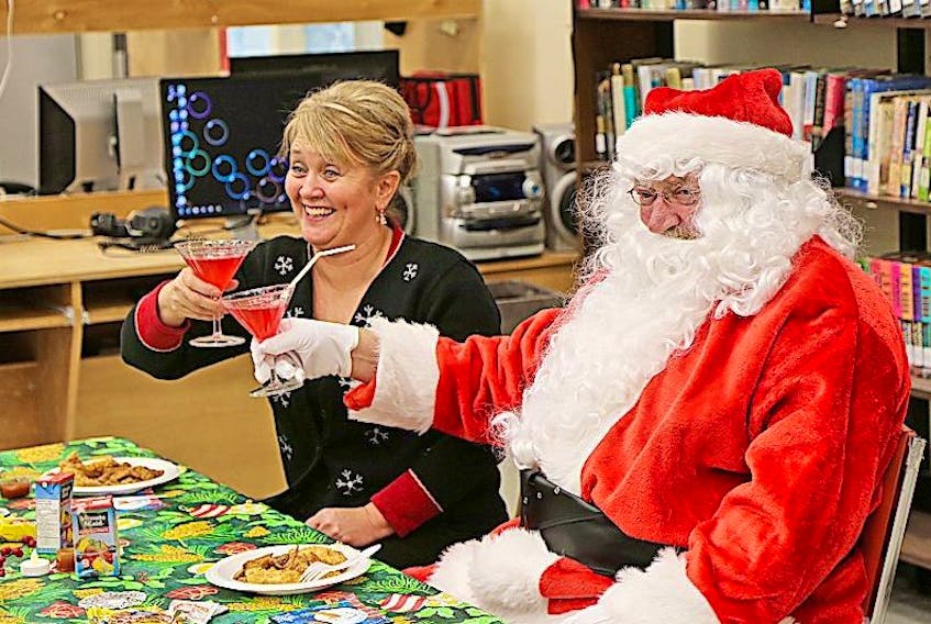 Santa cheers a Merry Christmas with Librarian Judy Hamilton.