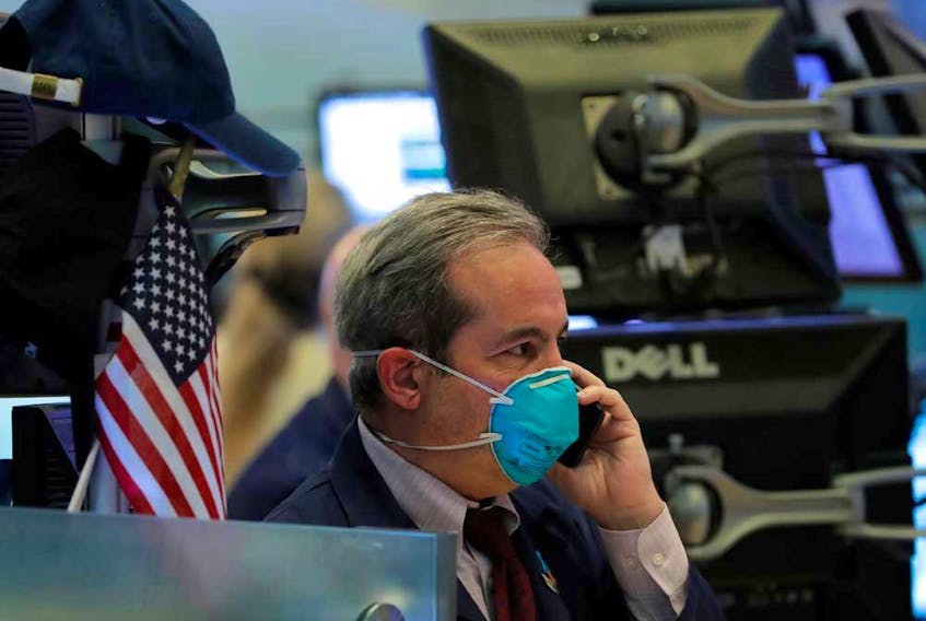 A trader wears a face mask on the floor of the New York Stock Exchange following traders testing positive for Coronavirus disease, in New York. 

