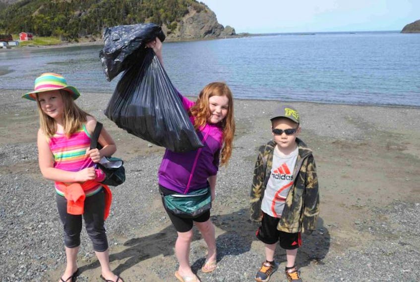 The children from St. James All-Grade School in Lark Harbour did a beach cleanup at Bottle Cove to celebrate World Oceans Day Monday. Holding up a bag of debris they collected are, from left, Grade 3 student Emily Spurrell, Grade 2 student Cheyenne Joyce and pre-schooler Owen Spurrell.