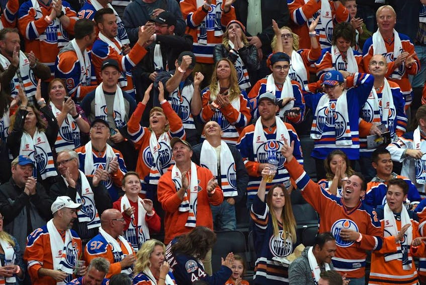 Fans celebrate a goal by Edmonton Oilers star Connor McDavid against the Calgary Flames during the season opener of NHL action at Rogers Place in Edmonton on Oct. 4, 2017.