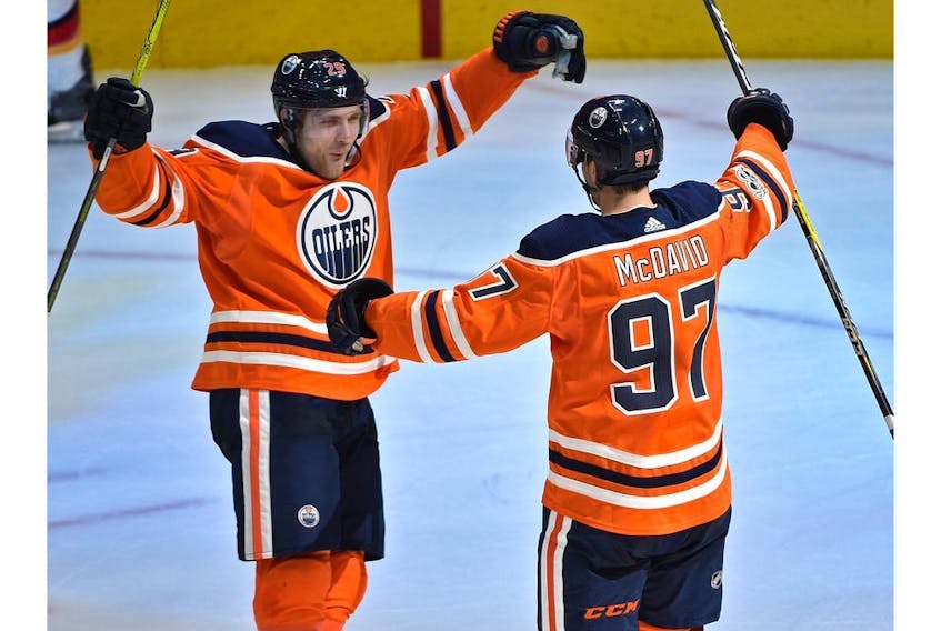 Edmonton Oilers Connor McDavid (97) celebrates with Leon Draisaitl (29) after scoring a hit trick against the Calgary Flames during the season opener of NHL action at Rogers Place in Edmonton, October 4, 2017.