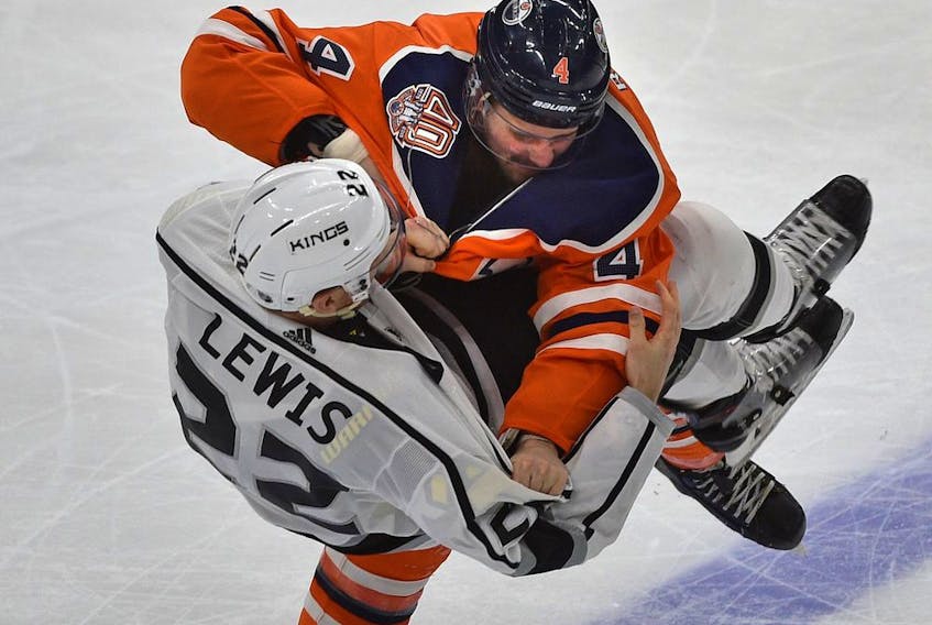 Edmonton Oilers Kris Russell (4) takes down Los Angeles Kings Trevor Lewis (22) in a fight during NHL action at Rogers Place in Edmonton, March 26, 2019. 