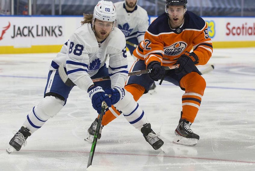 The Edmonton Oilers' Patrick Russell (52) chases the Toronto Maple Leafs' William Nylander (88) during second period NHL action at Rogers Place, in Edmonton Saturday Feb. 27, 2021. 