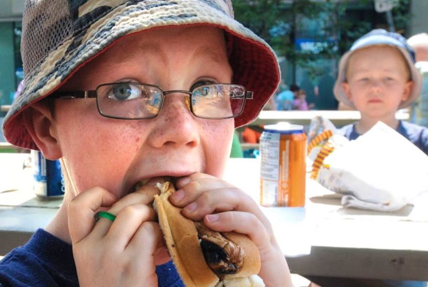 Kason MacAulay of St. Peters enjoys a hot dog at the Mayors Old Home Week Barbeque held on Fitzroy St. in Charlottetown. 