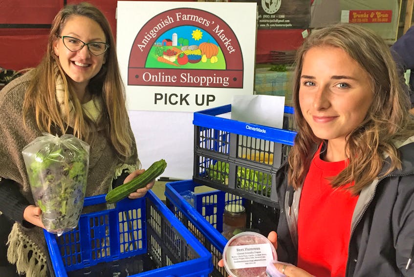 St. F.X. student Fiona Beaton (right) picks up her AFM Online order from Stephanie Cooper. She is one of the growing numbers of people accessing the online ordering service offered by Antigonish Farmers’ Market producers. Corey LeBlanc