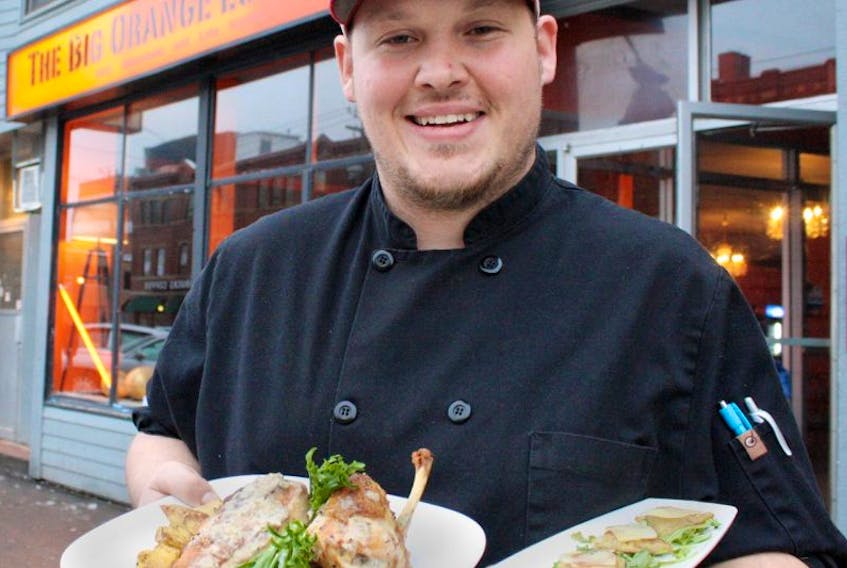 Chef James Oja, owner of The Big Orange Lunchbox, holds a roasted chicken entree and gnocchi ravioli appetizer, two items that have been added since moving into a new location in late November in downtown Charlottetown.