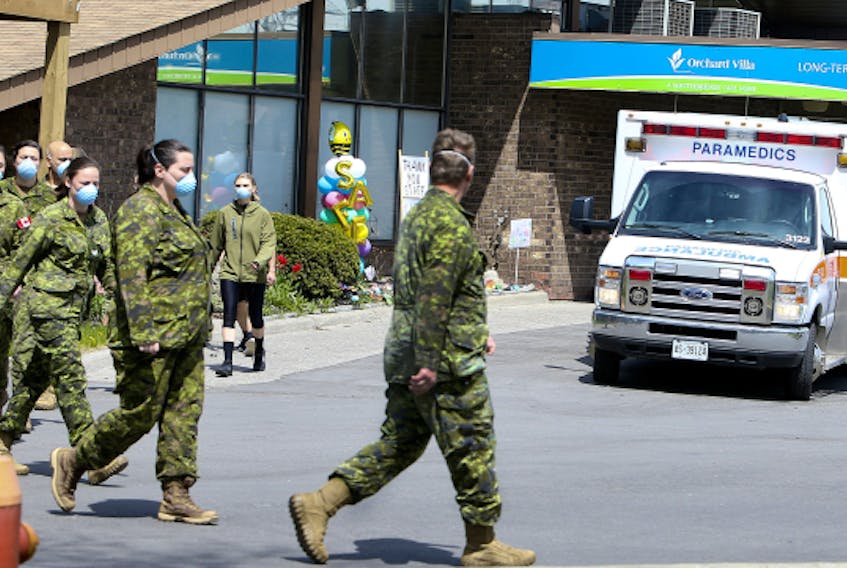 Members of the Canadian Armed Forces walk in front of Pickering's Orchard Villa long-term care home on Wednesday, May 6, 2020.  