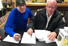 Peter MacDonald, left, and Winston Bryan, co-chairmen of the upcoming Canadian FireFighters Curling Championships in Charlottetown, go over team lists as preparations continue for the national competition. The Charlottetown Curling Complex is hosting the event from March 26-April 4. 
Bill McGuire/Special to The Guardian