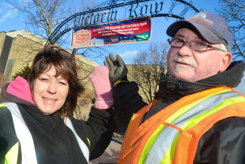 <span>Debbie Lee Clow and Deryl Hennessey, of Charlottetown’s public works department, point out the banner marking the entrance to a previous Christmas Market on Victoria Row. The annual market features vendors selling seasonal wares in a magical old-fashioned setting.</span>