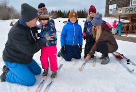 Thatcher MacKay, center, watches as his parents, Andrew and Robyn, assists his sisters, Elliott, second left, and Everleigh with their skis. Fears over the coronavirus led to the Cape Traverse family cancelling their March Break excursion to Halifax in favour of an outing closer to home.
Eric McCarthy/Journal Pioneer
