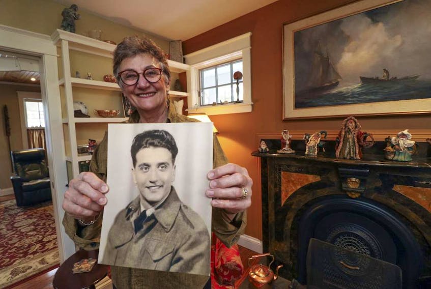 Wendy Oxley proudly displays a photo of her father, Almond Victor DeMarco, who was an anti-aircraft gunner and driver of a medical unit in Holland.