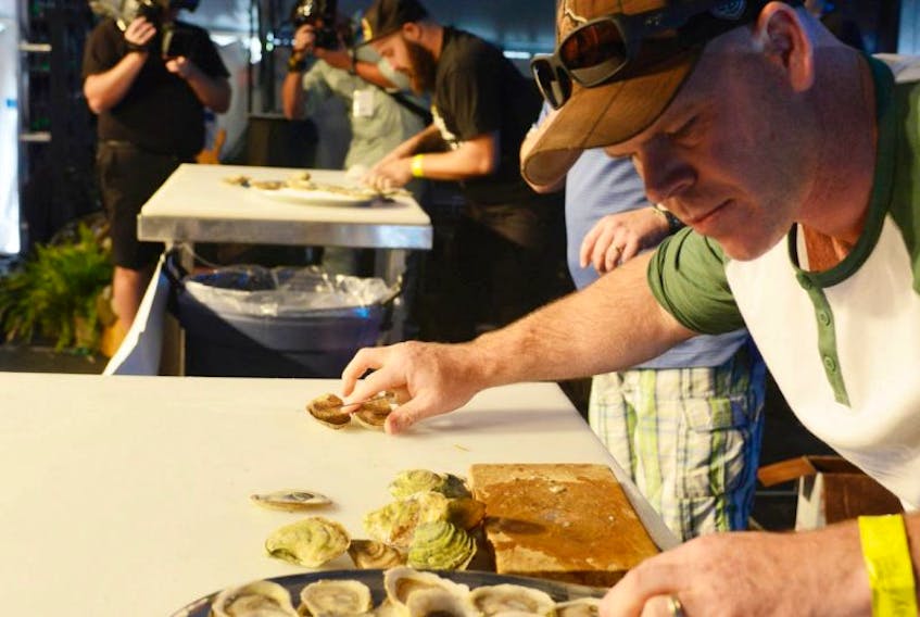 Josh Bishop, right, competes against fellow Ottawa resident Jesse Papastavros in the Raspberry Point International Oyster Shucking Championship at the P.E.I. Shellfish Festival in Charlottetown Sunday. Bishop is proprietor of The Whalesbone and Elmdale Oyster House and Tavern, while Papastavros is one of his employees.