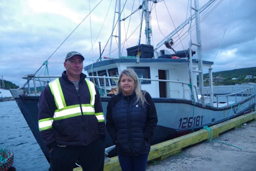 Richard and Melanie Marsh alongside their boat at Hickman’s Harbour. They raised questions last week about a new rule for the fall herring fishery, and are relieved the DFO changed the amendment.