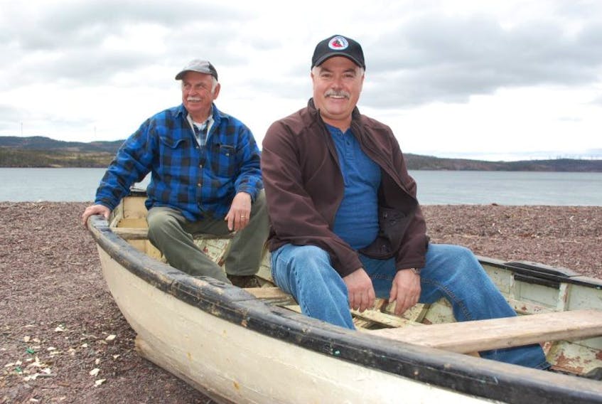 Derek Penney (right) sits in his rodney with boat builder Max Bursey on the day they took the boat to St. Phillips for restoration.