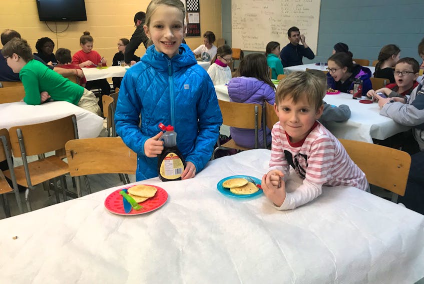 Lily (left) and Nate Smallwood (right) enjoy pancakes during the school's pancake breakfast before the holiday break.