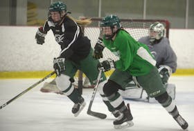 Defenceman Gabrielle Gray, left, and forward Maria Clinton go after a puck during Monday’s UPEI Panthers women’s hockey team’s practice at MacLauchlan Arena. 