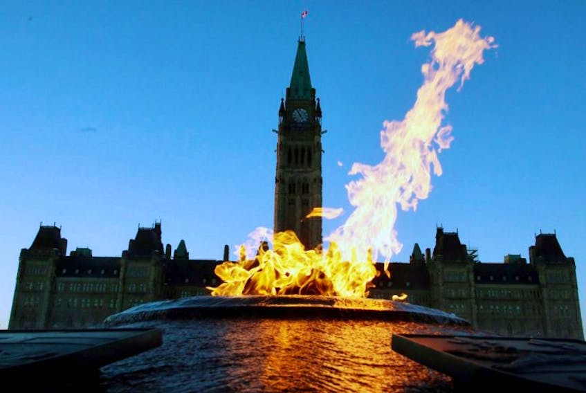 The Centre Block of the Parliament Buildings is shown through the Centennial Flame on Parliament Hill in Ottawa on Sunday, January 25, 2015.