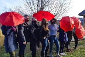 Staff members of the St. John's Status of Women's Council and Safe Harbour Outreach project pose with red umbrellas, a sign of solidarity with those in the sex industry. 