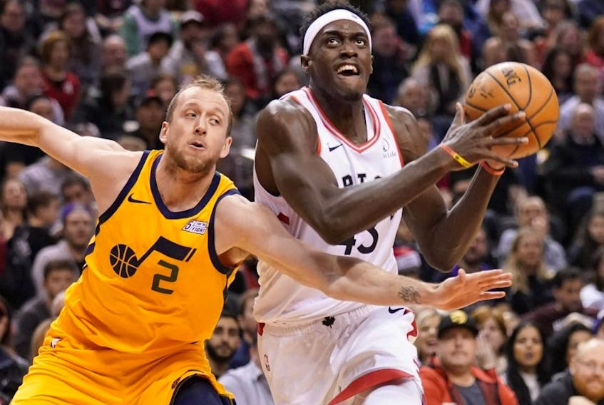 Raptors forward Pascal Siakam (right) drives to the net against Jazz forward Joe Ingles (left) during first half NBA action at Scotiabank Arena in Toronto on Sunday, Dec. 1, 2019.