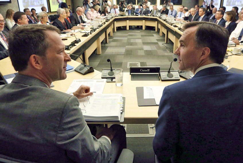 Deputy Minister Paul Rochon, left, speaks with then-federal Finance Minister Bill Morneau at a meeting with provincial and territorial finance ministers in Ottawa, Monday June 19, 2017.