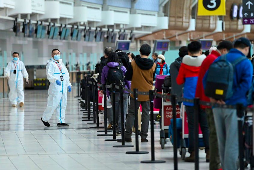People line up and check in for an international flight at Pearson International airport during the COVID-19 pandemic in Toronto on Wednesday, Oct. 14, 2020.