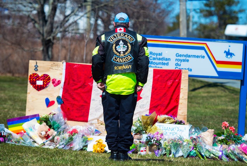 Former RCMP and naval officer Gerry White stands at attention in front of a memorial to fallen RCMP officer Const. Heidi Stevenson outside the Enfield RCMP detachment in Nova Scotia on Tuesday.