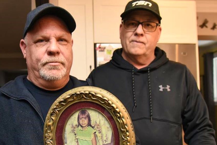 Brothers Bruce and Bill Blundell hold a picture of their deceased sister, Sheryl. Steve Somerville/Torstar