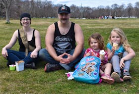 Sarah Hamilton, left, Dan Watts and his daughters Rose and Rainna enjoy some ice cream and onion rings from the Kiwanis Dairy Bar in Victoria Park on Sunday. Michael Robar/The Guardian