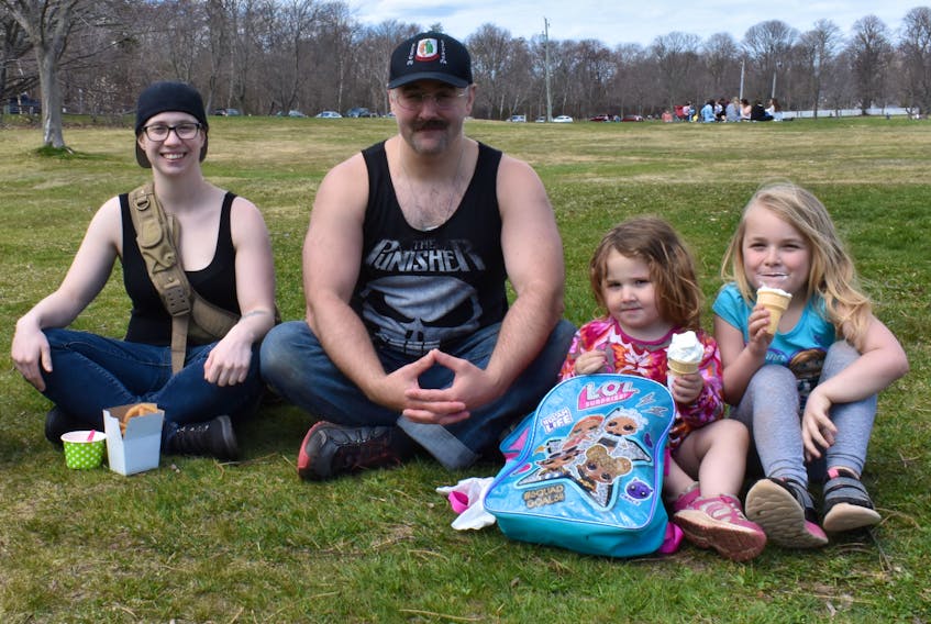 Sarah Hamilton, left, Dan Watts and his daughters Rose and Rainna enjoy some ice cream and onion rings from the Kiwanis Dairy Bar in Victoria Park on Sunday. Michael Robar/The Guardian